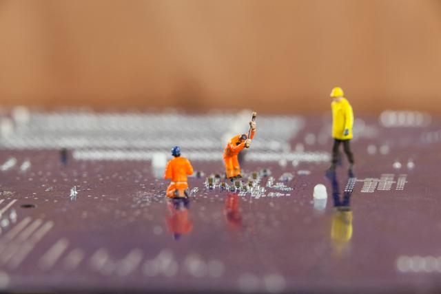 Miniature workers in construction outfits are depicted repairing a chip on a motherboard. This conceptual image can be used to represent technology repair, engineering, and maintenance. Ideal for illustrating articles on electronics, tech support, and hardware engineering.