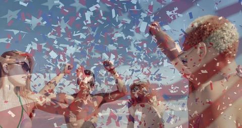Group of friends celebrating on beach under confetti