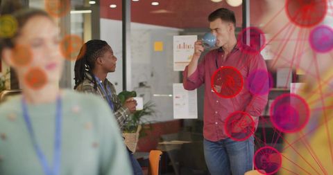 Colleagues discussing over coffee in creative office with data visualization overlays