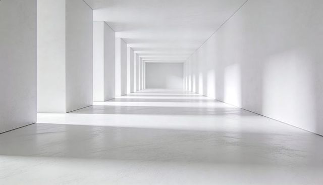 Leading Minimalist White Corridor with Repeating Pillars Casting Dramatic Light and Shadow
