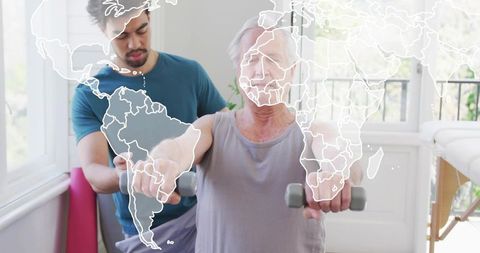 Senior Performing Dumbbell Rehabilitation with Personal Trainer in Sunlit Home Clinic