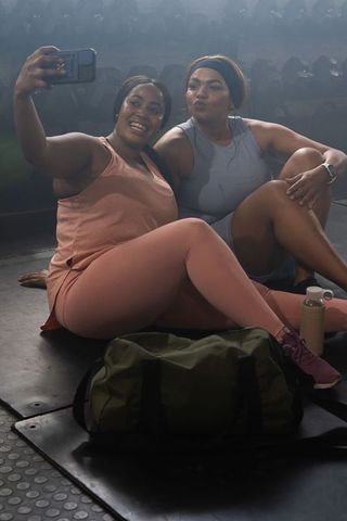African american women taking selfie after gym workout, smiling friends in colorful activewear