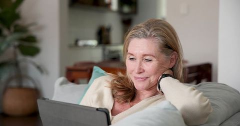 Senior Woman Relaxed at Home Using Tablet
