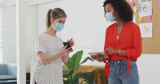 Two Businesswomen Collaborating While Wearing Face Masks in Office - Download Free Stock Images Pikwizard.com