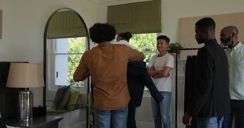 Groomsmen Laughing and Preparing Suits Before Wedding
