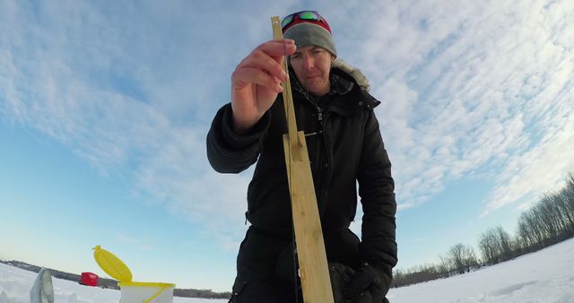 Man Ice Fishing on Frozen Lake in Winter Clothing - Download Free Stock Images Pikwizard.com