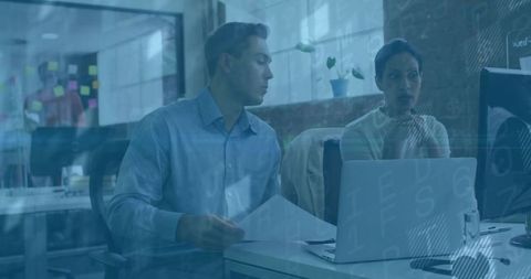 Office workers collaborating and reviewing documents in modern workspace