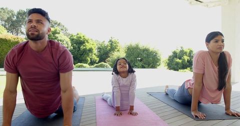 Family Doing Yoga Together Outdoor on Deck