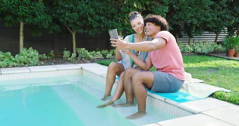 Joyful Couple Taking Selfie by Pool on Sunny Day