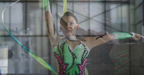 Determined female gymnast practicing ribbon routine indoors