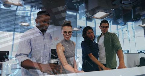 Cross-functional team collaborating around interactive touch table analyzing real-time data dashboar