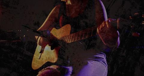 Teen musician playing acoustic guitar with stage lighting