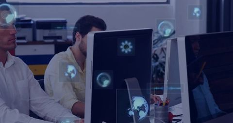 Coworkers collaborating at desktop monitors using holographic ar overlays in modern office