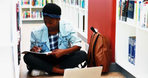 Focused Student Studying in Library with Technology