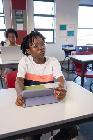 Focused Students Engaged with Technology in Modern Classroom