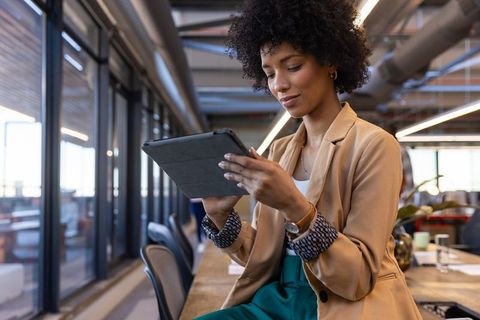 Confident businesswoman using digital tablet in modern office