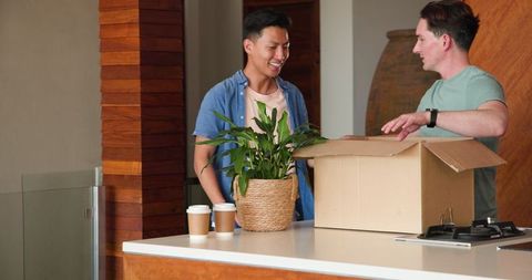Happy Couple Unpacking Together in Kitchen with Coffee