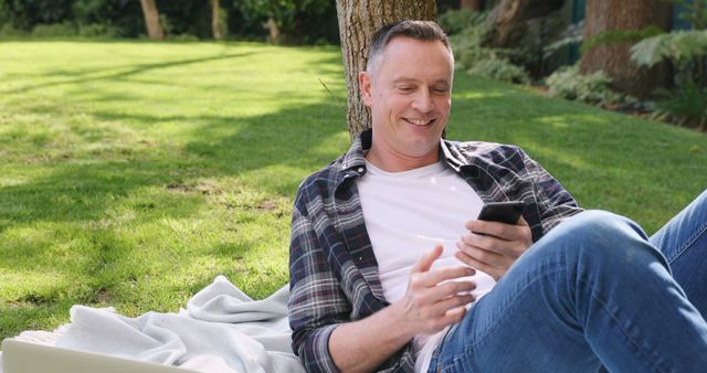 Man Relaxing on Outdoor Picnic Blanket Using Smartphone in Park - Download Free Stock Images Pikwizard.com