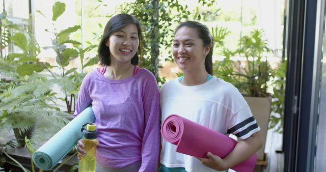 Two Women Chatting After Yoga Class Holding Mats and Water Bottles - Download Free Stock Images Pikwizard.com