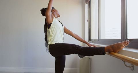 Confident African American Woman Stretching at Window Before Workout - Download Free Stock Images Pikwizard.com