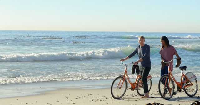 Couple Enjoying Leisurely Bike Ride on Beach with Waves in Background - Download Free Stock Images Pikwizard.com