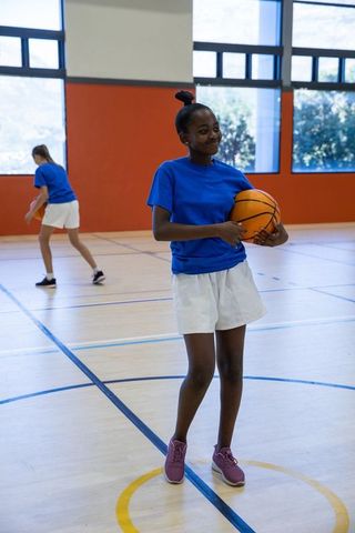 Teen Girls Engaging in Basketball Practice in Gym