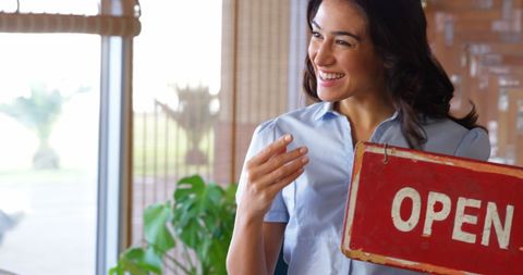 Smiling asian businesswoman flipping open sign ready for day