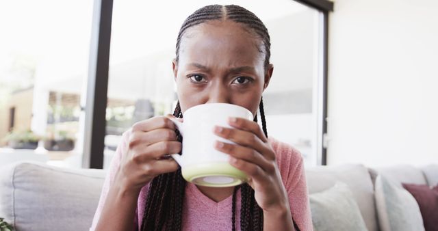 Young Woman Sipping Tea on Sofa in Living Room - Download Free Stock Images Pikwizard.com