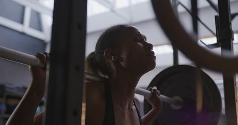 Powerful barbell back squat in modern gym setting