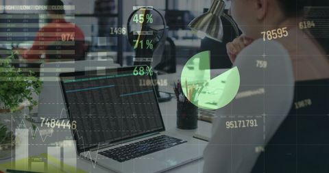 Financial Analyst Analyzing Data on Laptop in Modern Office