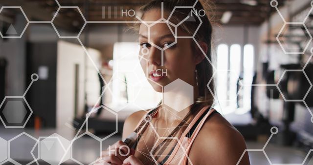 Fit woman preparing for workout in a gym surrounded by molecular graphics overlay. Illustrates concept of fitness and technology. Useful for articles on health, science, sports innovation, and biotechnology in fitness.