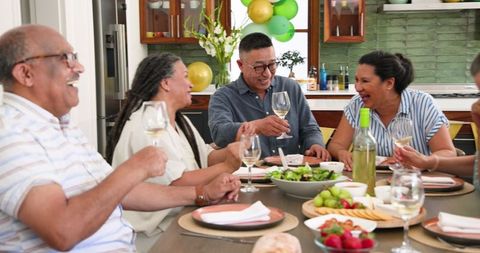 Diverse Senior Friends Celebrating with Wine at Home Gathering