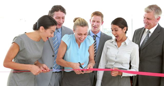 A diverse group of professionals, including Caucasian and Hispanic adults, are celebrating a ribbon-cutting ceremony, with copy space. Their cheerful expressions and business attire suggest a significant corporate event or company milestone.