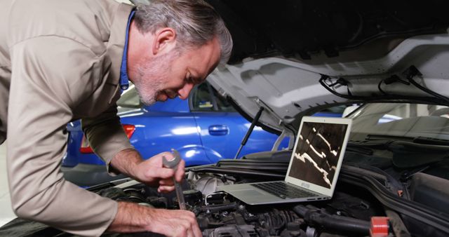 Auto Mechanic Repairing Car Engine Using Laptop for Diagnostics - Download Free Stock Images Pikwizard.com