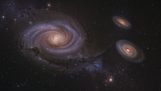 Grand spiral galaxy with glowing yellow core, blue star-forming arms and twin companions