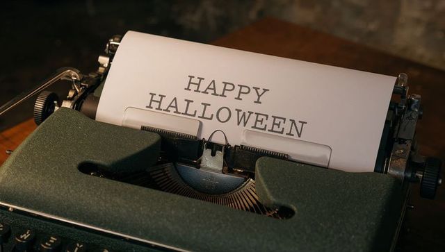 Vintage typewriter typing happy halloween on cozy wooden desk