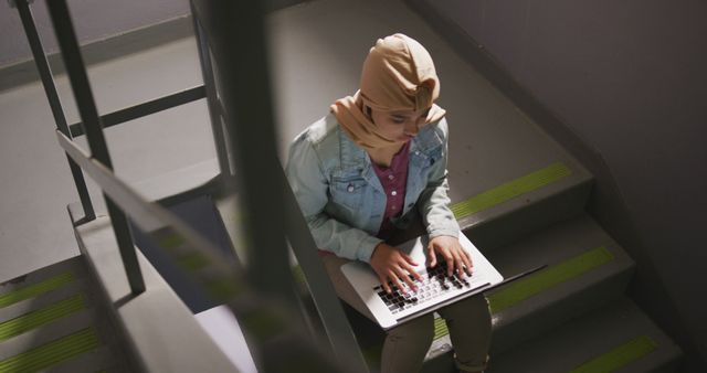 Biracial female student sitting on stairs and using laptop with copy space - Download Free Stock Photos Pikwizard.com