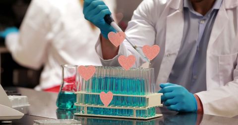 Scientist Handling Test Tubes with Digital Hearts Graphic
