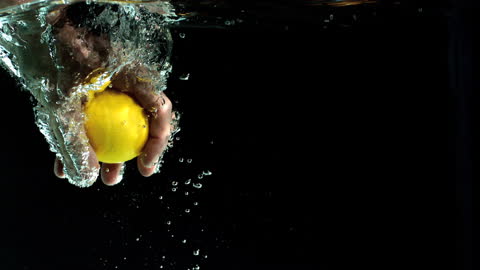 Hand Grabbing Lemon Underwater in Dynamic Splash Moment