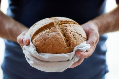Homemade Bread in Hands with Linen Cloth