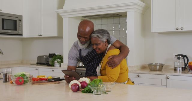 African american senior couple having a image call on digital tablet in the kitchen at home. retirement senior couple lifestyle living concept