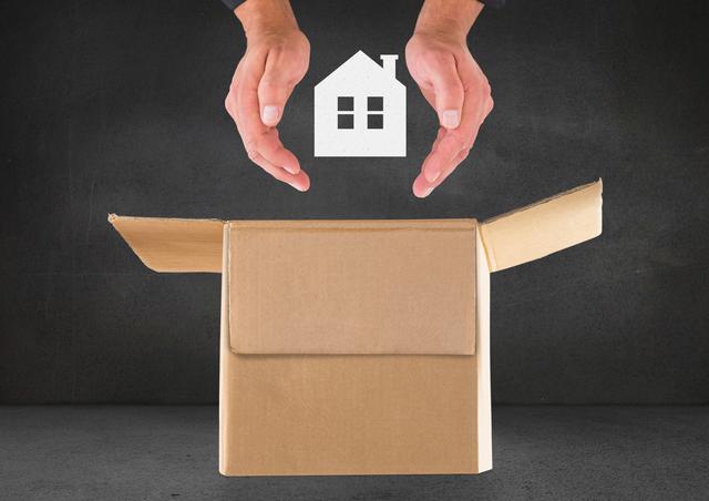 Digital composition of man hand protecting house over cardboard box against black background