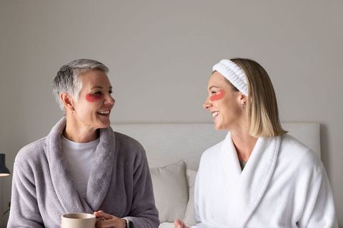Senior and middle-aged women enjoying cozy home spa morning with eye patches and robes