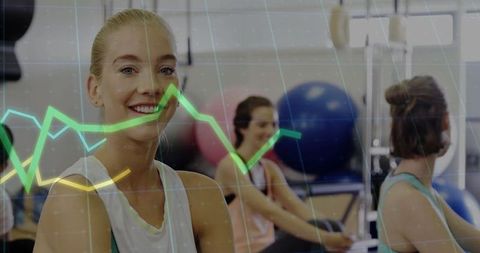 Smiling woman exercising with data analytics in modern gym