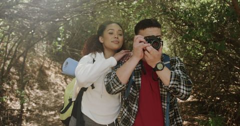 Happy Wanderlust Couple Photographing in Sunlit Forest