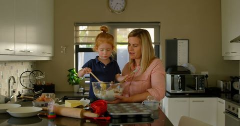 Mother and Daughter Bonding Over Baking in Home Kitchen