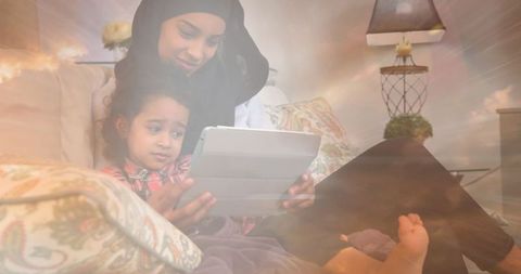 Mother and Daughter in Hijab Bonding with Tablet Cloud Theme