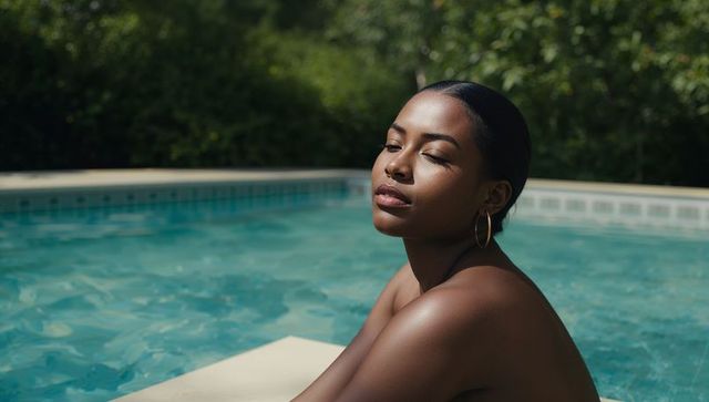 Sunlit woman relaxing at pool edge in swimwear with closed eyes and gold hoop earrings