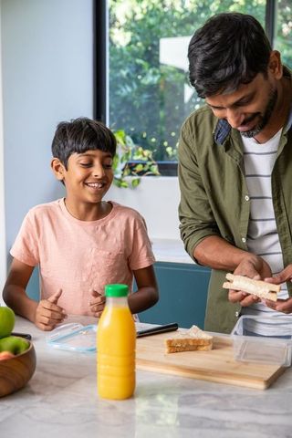 Father and son enjoy quality time making sandwiches in kitchen