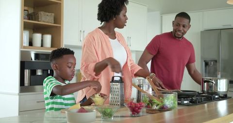 African american family preparing healthy meal at kitchen island, child helping cook